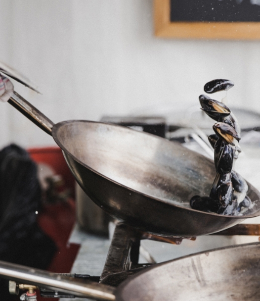 Mussels are tossed around in the pan while cooking.
